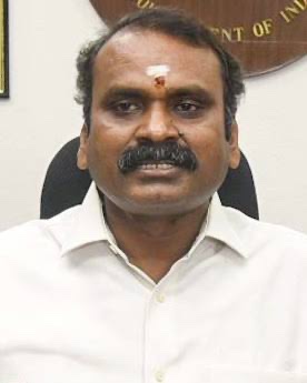 Head-and-shoulders portrait of Dr. L. Murugan in a white shirt, seated in his office