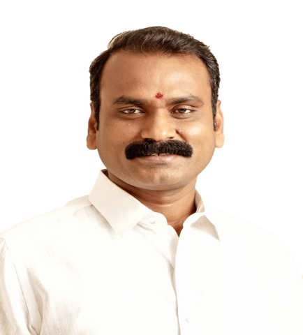 Portrait of Dr. L. Murugan in a white shirt against a light background
